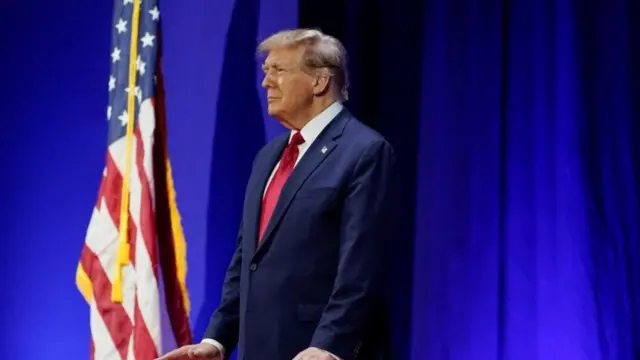 Donald Trump, junto a la bandera de Estados Unidos.