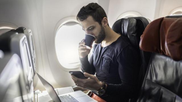 Homem com celular e laptopapostar no jogo do brasilavião