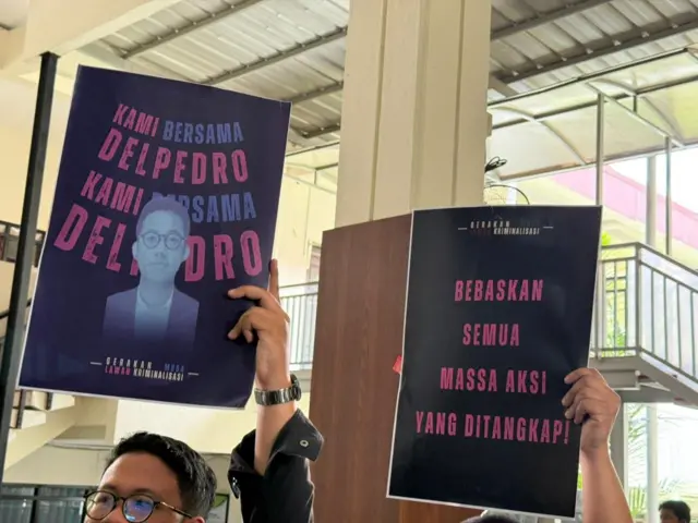 Seorang pria mengangkat poster dukungan untuk Delpedro.