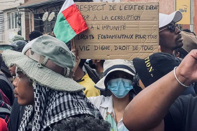 Un manifestant brandit une pancarte lors d'une manifestation contre les coupures répétées d'eau et d'électricité à Antananarivo, le 30 septembre 2025.