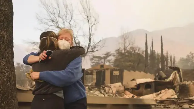 Мелісса Янг (праворуч) обіймається з сусідкою біля згарища, що колись було її будином в Альтадені