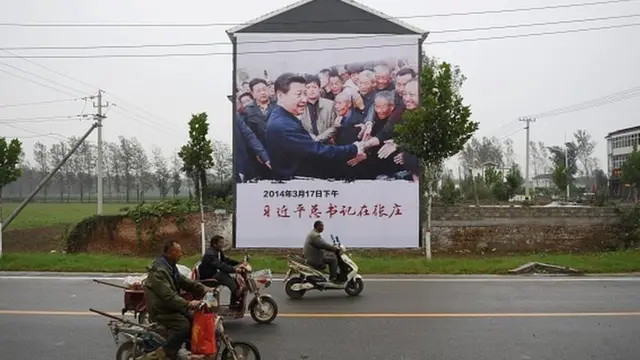 Cartaz do presidente Xi Jinping visitando pessoas que vivem na pobreza