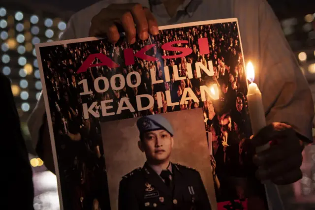 Peserta aksi dari Tim Advokat Penegakan Hukum dan Keadilan (TAMPAK) memegang poster saat aksi seribu lilin dan doa bersama untuk Alm Brigadir Yosua Hutabarat di Bundaran HI, Jakarta, Jumat (22/7/2022). 