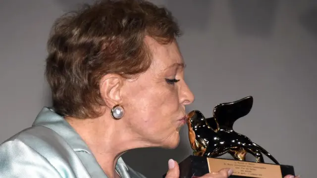 وسط تصفيق الجمهور المحتشد لحظة تكريمها، رفعت آندروز جائزة الأسد الذهبي وقبلتها