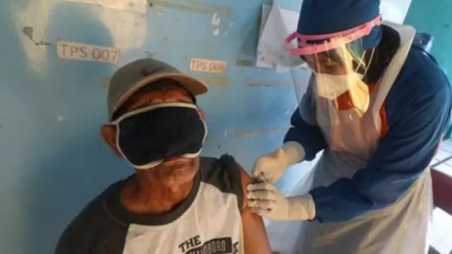 Petugas kesehatan menyuntikkan vaksin COVID-19 kepada ketua RT di Kota Kediri, Jawa Timur, Rabu (17/03).