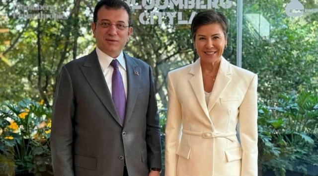 Takım elbiseli İmamoğlu ve beyaz bir takım giymiş kısa saçlı bir kadın poz veriyor.