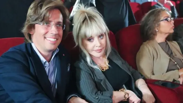 Галкін та Пугачова сидять на червоних кріслах в концертній залі