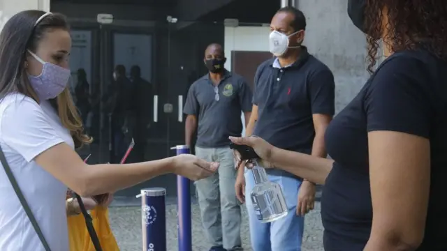 Jovem passa álcool gel antesaplicativo para jogos da loteriaentrar na prova do Enem 2020