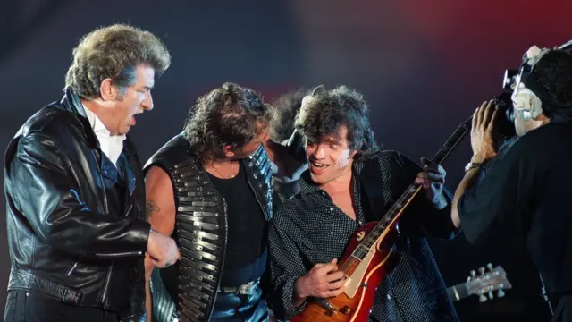 Johnny Hallyday a plus de 500 duos avec 187 artistes. Ici avec le chanteur français Eddy Mitchell qu'il connaît depuis son enfance et le guitariste Paul Personne en concert au Parc des Princes à Paris.