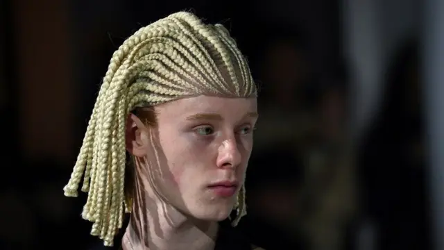 Un mannequin au défilé Comme Des Garçons à Paris avec des tresses.