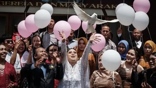 Pengantin Maria Delsa Visianika (tengah) dan pengantin pria Gideon Hermantoko (kedua dari kiri) melepas merpati saat upacara pernikahan mereka di Gereja Kristen Epivani Java di Parakan, Jawa Tengah, pada 16 Desember 2023.