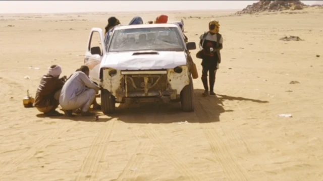 Dadka ku jira iyo kuwo ag dhooban baabuurka dusha sare ka furan ee saxaraha dhex taagan