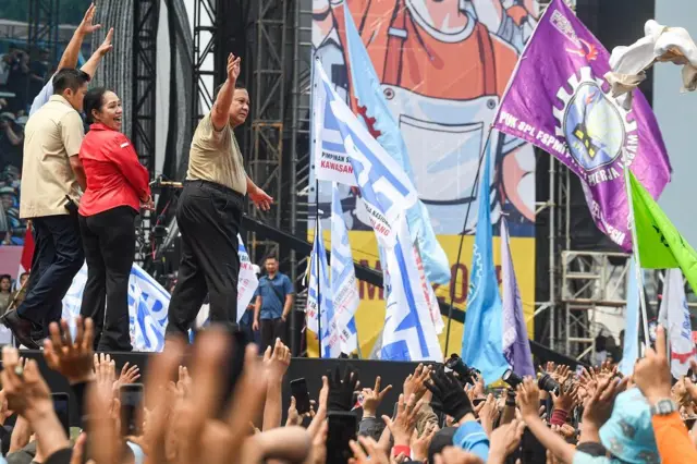 Presiden Prabowo Subianto melempar baju usai menyampaikan pidatonya pada perayaan Hari Buruh Internasional 2025 di kawasan Monas, Jakarta, 1 Mei 2025.