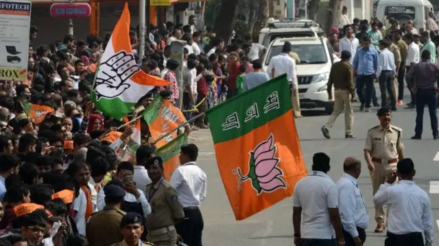 રસ્તા પર એકઠી થયેલી ભીડમાં લોકોના હાથમાં ભાજપનો ઘ્વજ