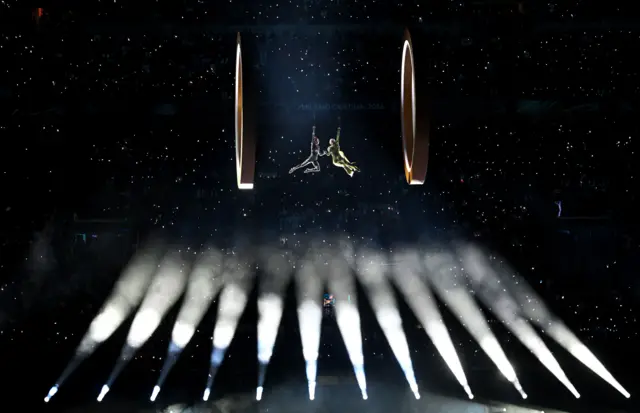 Воздушные гимнасты под крышей стадиона Сан-Сиро во время церемонии открытия