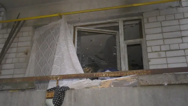 Квартира жінки, яка зносить додому сміття. У вікнах немає скла, вони завішані брудною фіранкою, на стінах - сліди нещодавньої пожежі, яку влаштувала жінка.