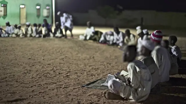 స్కూలులో నేల మీద కూర్చున్న విద్యార్థులు