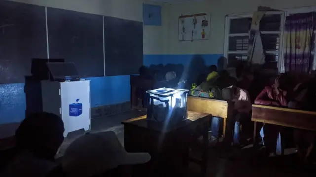 Un bureau de vote éclairé par une torche