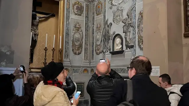 Kilisenin içindeki freskin fotoğrafını çeken ziyaretçiler