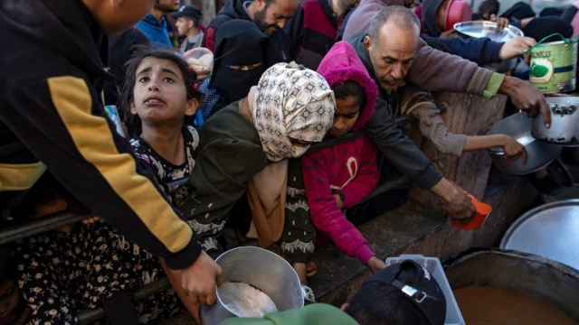 الأطفال والكبار يتزاحمون للحصول على المساعدات الغذائية.