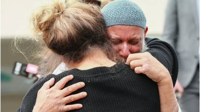 ওয়েলিংটনে মসজিদে আসা একজনের সাথে আলিঙ্গন করে সম্প্রীতি প্রকাশ করছেন নিউজিল্যান্ডের এক নাগরিক।