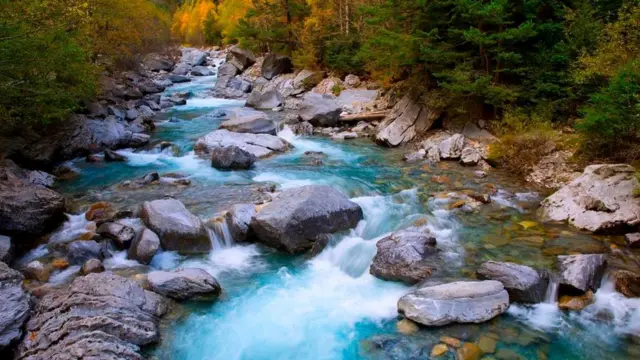 La imagen de un río que fluye entre unas piedras
