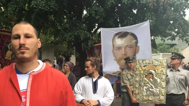 Људи на улици са фотографијама Николаја Другог