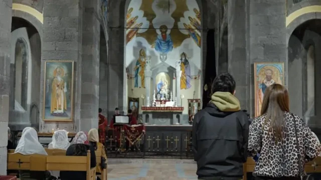 چند نفر داخل کلیسا در حال دعا