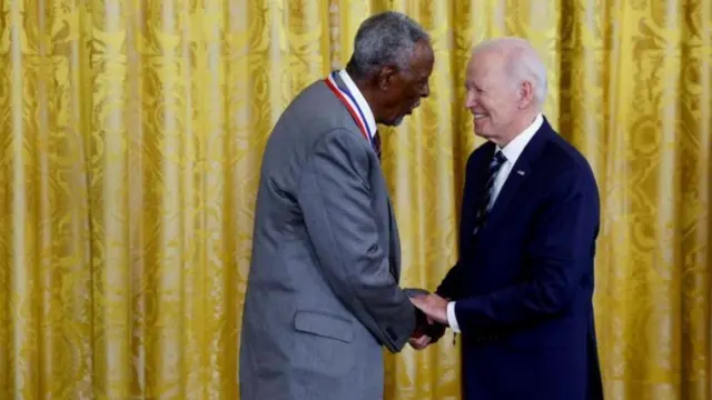 Pirof. Gabbisaa yeroo badhaasa US Pirezidant Joo Baayidanirraa badhaasa fudhatu