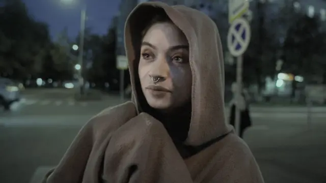 Burnida halga bor, boshiga kapyushon kiygan yosh qiz