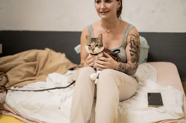 Sığınakta elinde kedisini tutan bir kadın