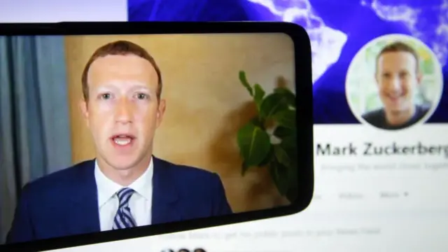 الرئيس التنفيذي لشركة فايسبوك، مارك زوكربيرج، على شاشة الهاتف المحمول وهو يدلي بشهادته عن بُعد أثناء جلسة استماع للجنة التجارة والعلوم والنقل التابعة لمجلس الشيوخ الأمريكي بعنوان "هل تمكّن الحصانة الكاسحة للقسم 230 من السلوك السيئ للتكنولوجيا الكبيرة؟" في مبنى الكابيتول هيل في واشنطن العاصمة بالولايات المتحدة.