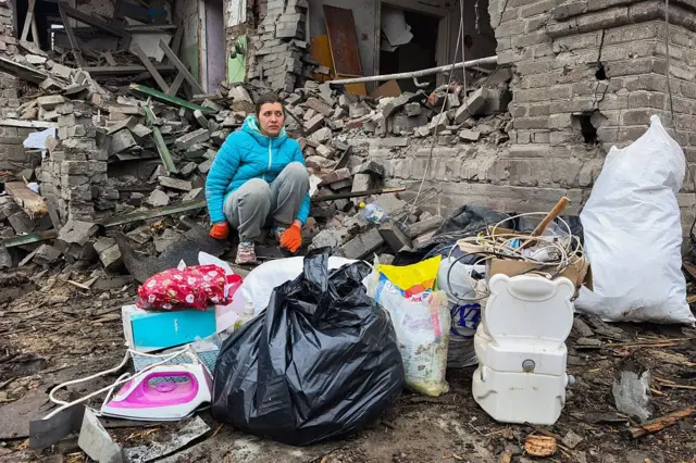 Жительница Краматорска сидит на развалинах дома, разрушенного в результате российского обстрела