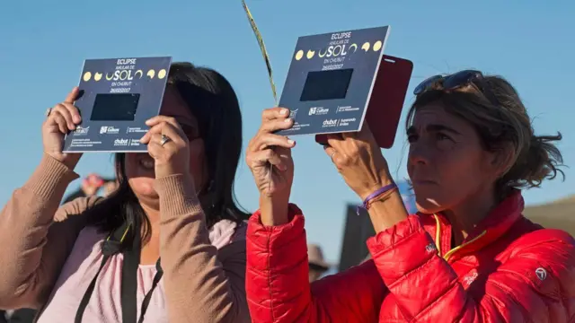 Dos mujeres ven el eclipse mediante protectores