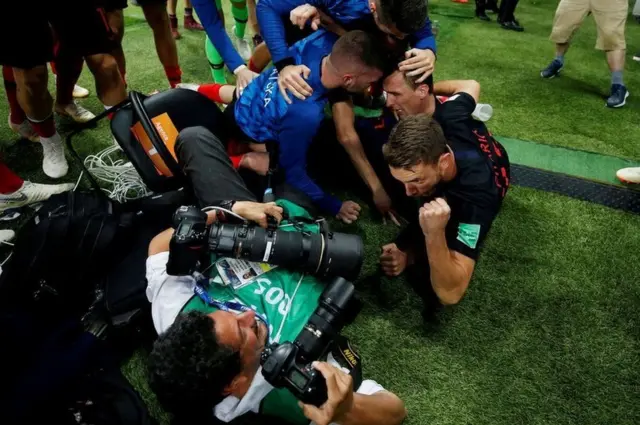 นักเตะทีมชาติโครเอเชียหลายคนล้มตัวทับช่างภาพขณะร่วมแสดงความดีใจ หลังยิงประตูขึ้นนำอังกฤษในช่วงต่อเวลา