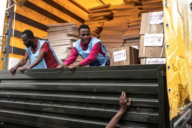 Des fonctionnaires électoraux de la Commission électorale nationale indépendante (CENI) ferment un camion rempli de matériel électoral pour le distribuer à Kinshasa le 19 décembre 2023