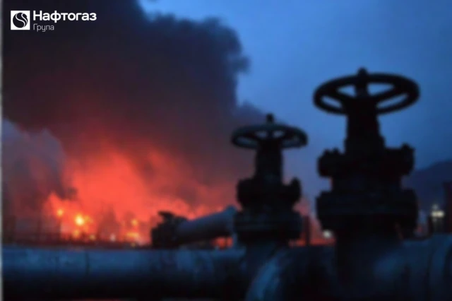 Газові вентилі на тлі пожежі на газовому об'єкті після удару Росії