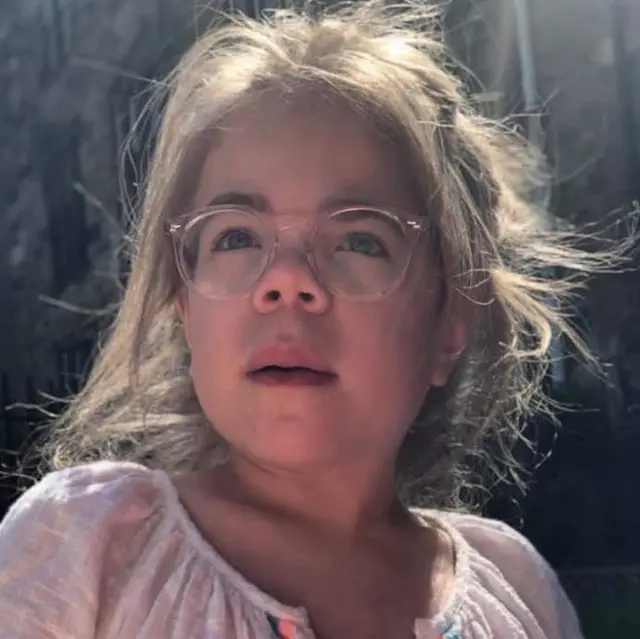 Sophia Scott'ın 10'lu yaşlarından bir fotroğraf. Sophia kadrajın hafif dışına bakarken görülüyor. Uzun, sarı saçları geriye doğru toplanmış. Büyük, pembe çerçeveli gözlükler takıyor ve beyaz bir yazlık üst giymiş.