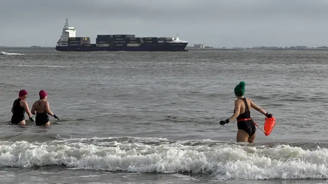 سویتلانا همراه با شناگران دیگر داخل دریای ایرلند می‌شوند و یک کشتی باری در پس زمینه