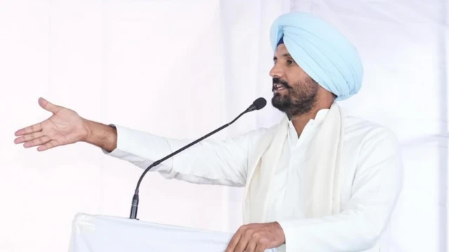 ਸਫੇਦ ਕੁੜਤੇ ਪਜਾਮੇ ਅਤੇ ਅਸਮਾਨੀ ਨੀਲੇ ਰੰਗ ਦੀ ਪੱਗ ਵਿੱਚ ਮੰਚ ਤੋਂ ਬੋਲਦੇ ਹੋਏ ਰਾਜਾ ਵੜਿੰਗ।