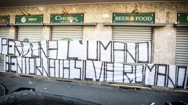 "iska cafi, soona dhawaaw Silvia Romano" ayaa ku qoran boorkan oo lagu dhejiyay magaalada ay ka soo jeeda ee Milan.