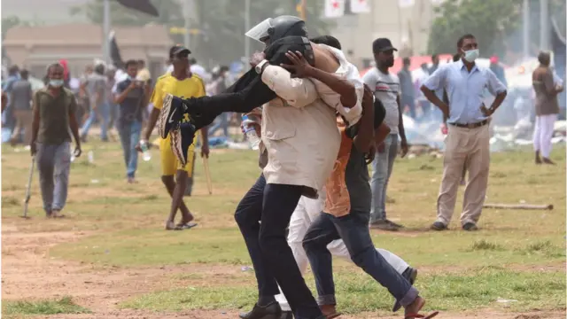 সরকারবিরোধী একজন বিক্ষোভকারী আহত হন। তাকে তুলে নিয়ে যাচ্ছেন অন্য বিক্ষোভকারীরা।