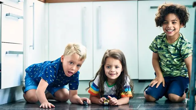 Niños pequeños jugando con autos pequeños