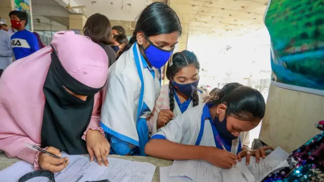 ঢাকার সাউথ পয়েন্ট স্কুলে টিকা নেবার জন্য স্কুল শিক্ষার্থীরা ফর্ম পুরোন করছে, ১২/০১/২০২২
