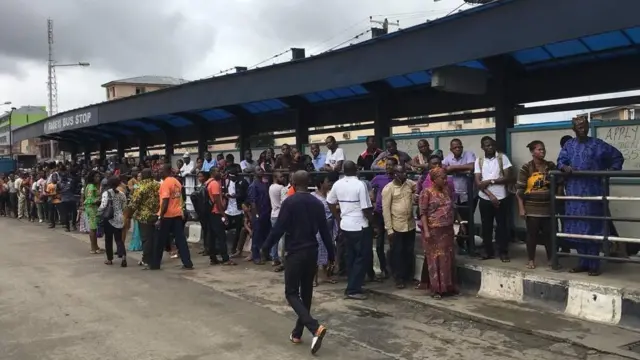 People stranded waiting for buses.