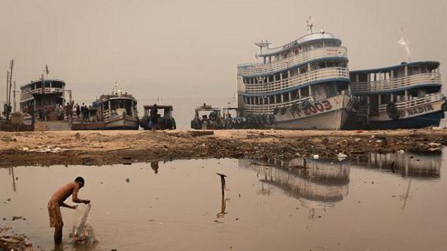 Rio seco em Manaus com barcos ao fundo