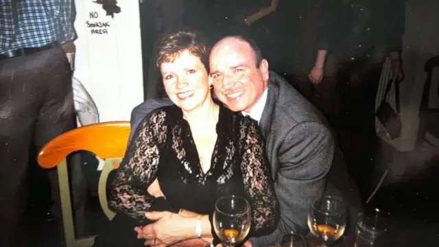 Una fotografía familiar de Patricia y John Harris sonriendo del brazo en lo que parece una fiesta o evento.