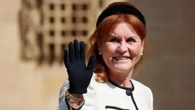 Sarah Ferguson siyah eldiven takılı sağ elini yukarı kaldırmış halde selamlıyor