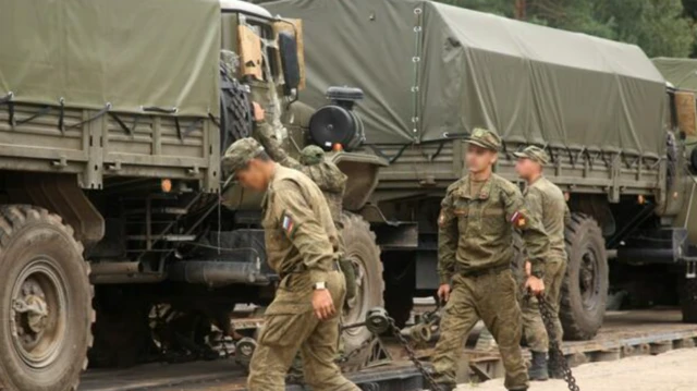 Солдаты в российской военной форме с заблюренными лицами на фоне грузовых автомобилей, на которых они приехали на учения. Фото предоставлено Минобороны Беларуси