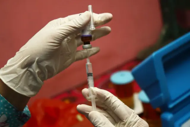 Petugas kesehatan menyiapkan vaksin Campak Rubella sebelum imunisasi di pos layanan kesehatan terpadu di Desa Wanasari, Jawa Barat,